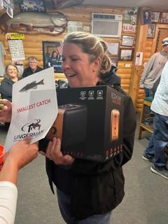 An Ungerman team member accepting the "smallest catch" prize at the company fishing tournament.