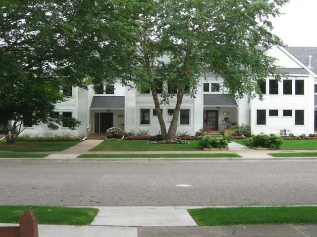 Restored row of Minneapolis association townhomes with new siding, roofing, and landscaping after fire damage restoration by Ungerman