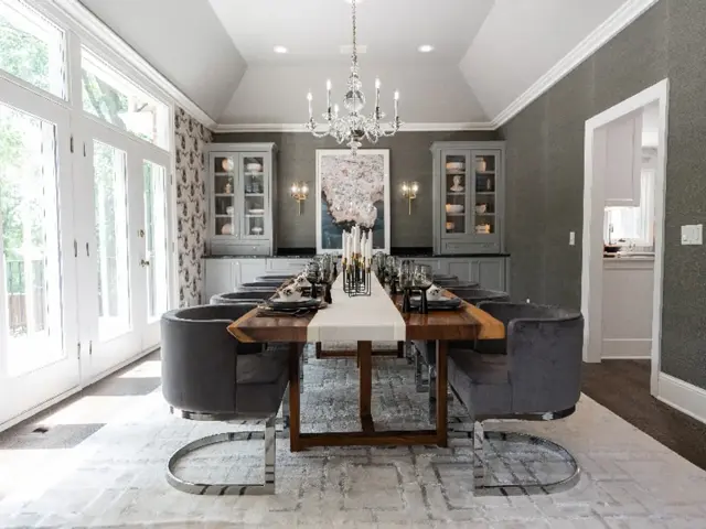 Remodeled Minnetonka dining room with grasscloth walls, glass-front china cabinets, and a chandelier beneath a vaulted ceiling after ice dam damage restoration by Ungerman