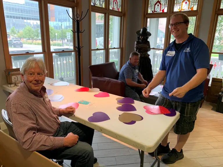 Volunteers cutting and laying out paper hearts for the Ronald McDonald House Charities gala