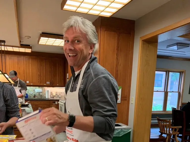 An Ungerman volunteer in an apron putting together a meal in the Ronald McDonald House kitchen