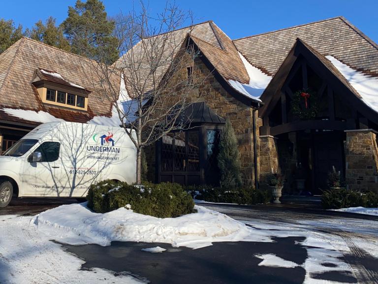 Ungerman service van parked at a residential home during a winter emergency response job