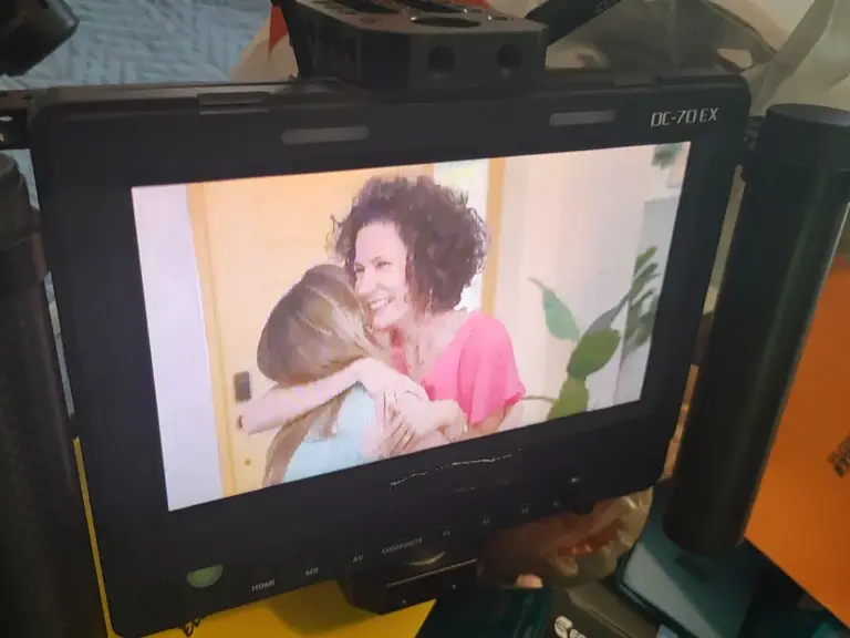 A monitor showing an emotional embrace during a reveal