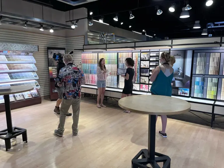 Crew filming inside Ungerman's selection showroom, surrounded by tile, flooring, and paint sample displays