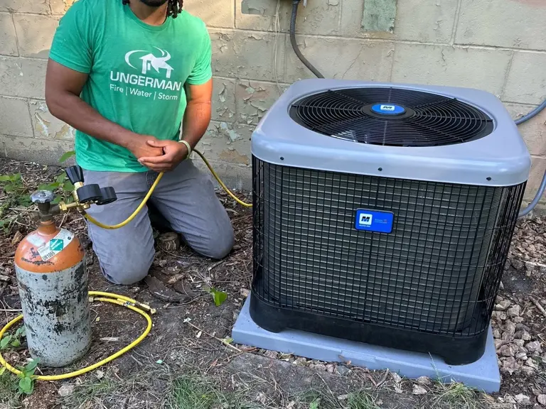 An Ungerman HVAC technician working on an outdoor air conditioning condenser at a Twin Cities home