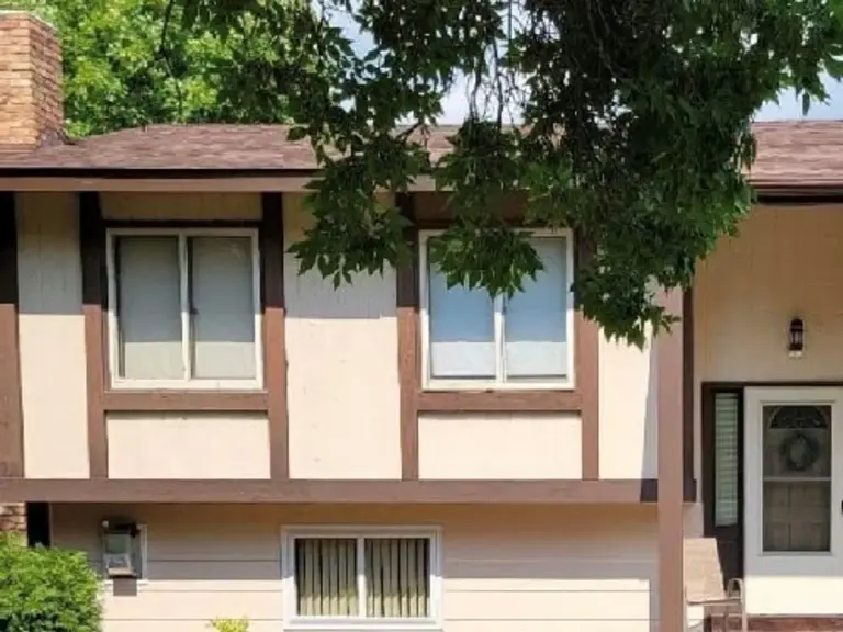 The same elevation after restoration, with the lower level rebuilt and the siding and tudor trim matched back to the rest of the house
