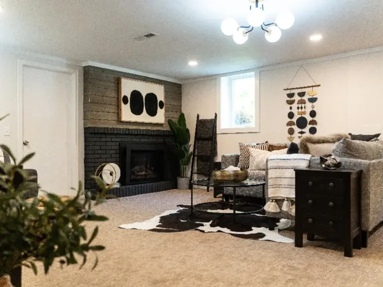 The same fireplace wall painted and restyled with mid-century furnishings and a hide rug
