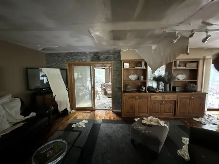 Dining area with a wood built-in hutch beside the patio door, ceiling drywall down after fire and water damage