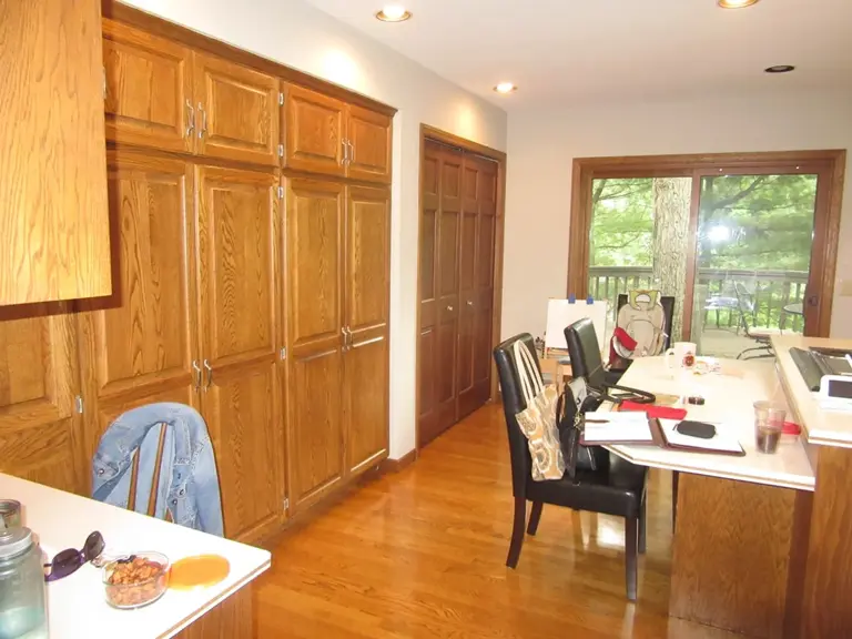 Original floor-to-ceiling oak cabinet bank beside the dining area before remodeling