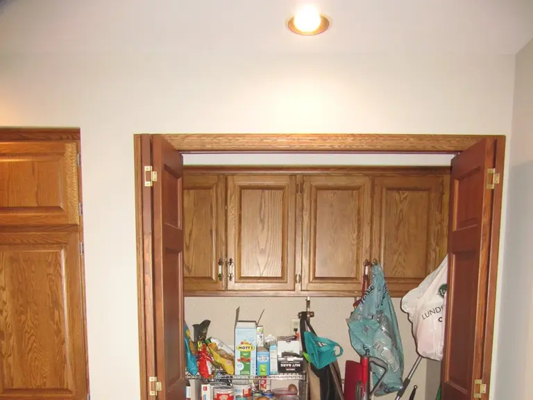 Original bifold closet pantry packed with groceries and bags before remodeling