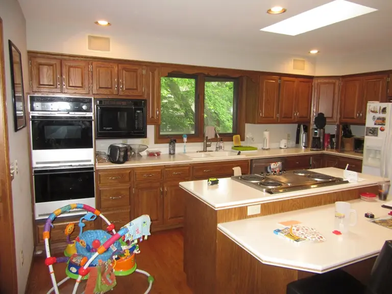 Original Edina kitchen with oak cabinets, laminate counters, and a black wall oven beneath a skylight before remodeling