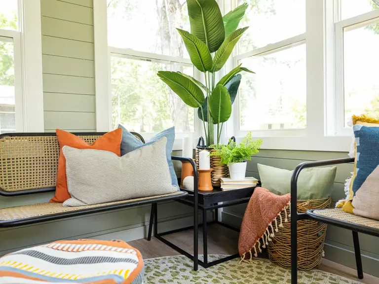 Rebuilt front porch as a bright sunroom with wraparound windows, vaulted ceiling, and seating