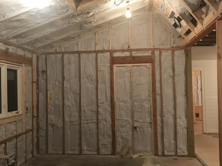 The kitchen area stripped to insulated framing with the vaulted ceiling exposed during the remodel