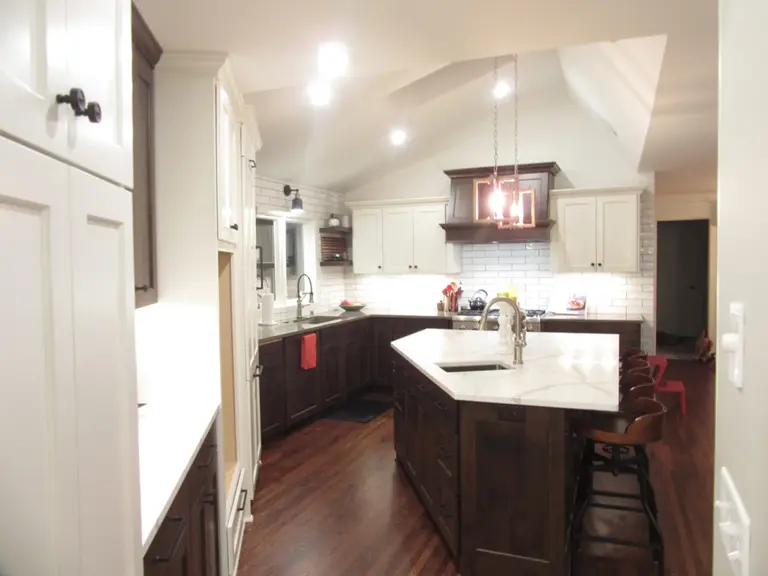 The same space finished, with the kitchen open to the living area beneath the vaulted ceiling