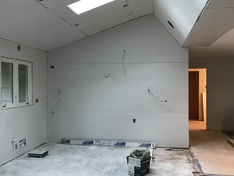 The opened living space drywalled but unfinished, with the new vaulted ceiling and skylights in place