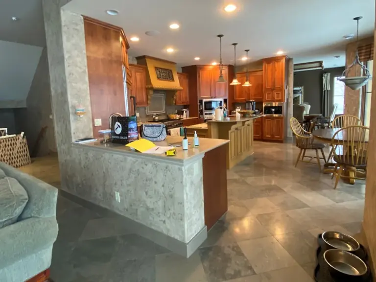 Closed-in Plymouth kitchen before restoration, with a stone-clad peninsula walling off the range, island, and breakfast nook