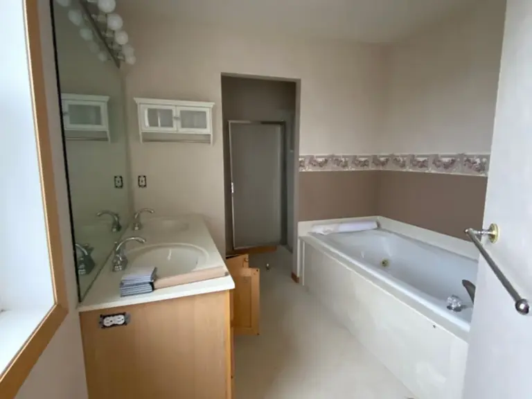 Original primary bathroom looking toward the sunken garden tub and enclosed shower before fire restoration