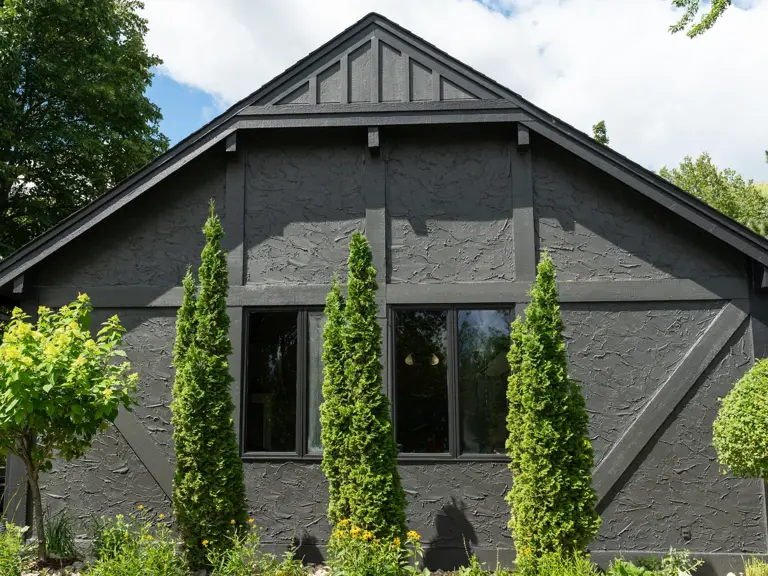 The same gable with new shingles and the stucco repainted charcoal with dark tudor timber trim