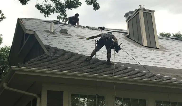 An Ungerman roofing crew tearing off old shingles and laying new underlayment on a Twin Cities home