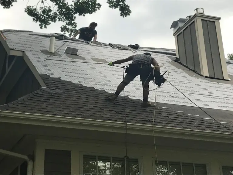 An Ungerman roofing crew tearing off old shingles and laying new underlayment on a Twin Cities home