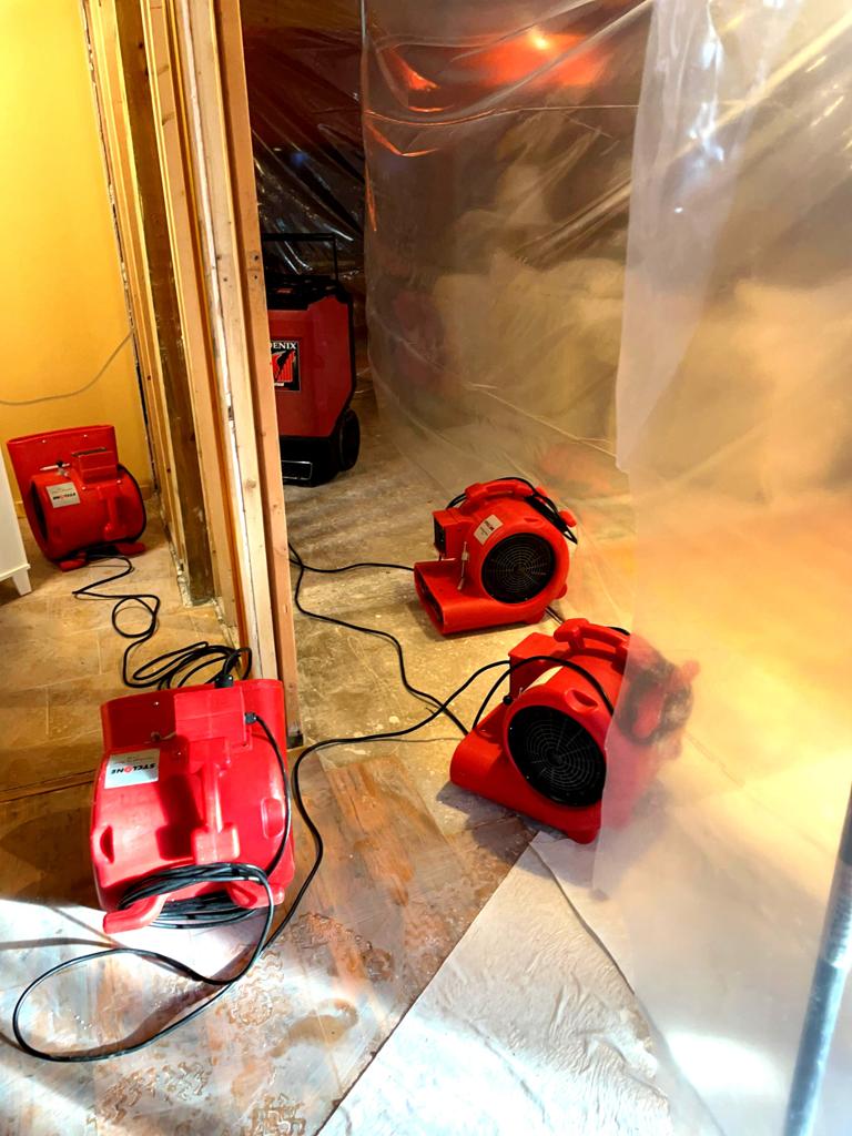 Drying fans and a dehumidifier deployed during water damage restoration.