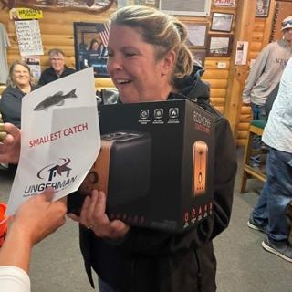 An Ungerman team member accepting the "smallest catch" prize at the company fishing tournament.