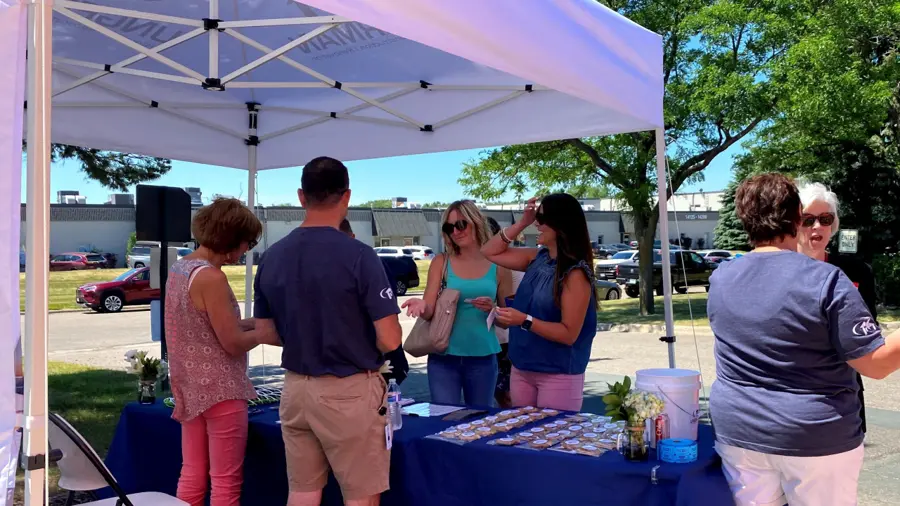 Guests gathered under a white event tent at the Minnesota Multi Housing Association summer social