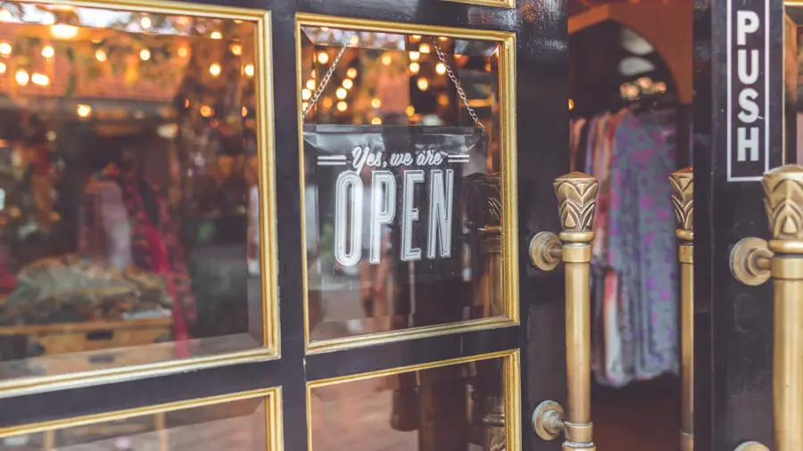 A storefront window with an open-for-business sign after a loss